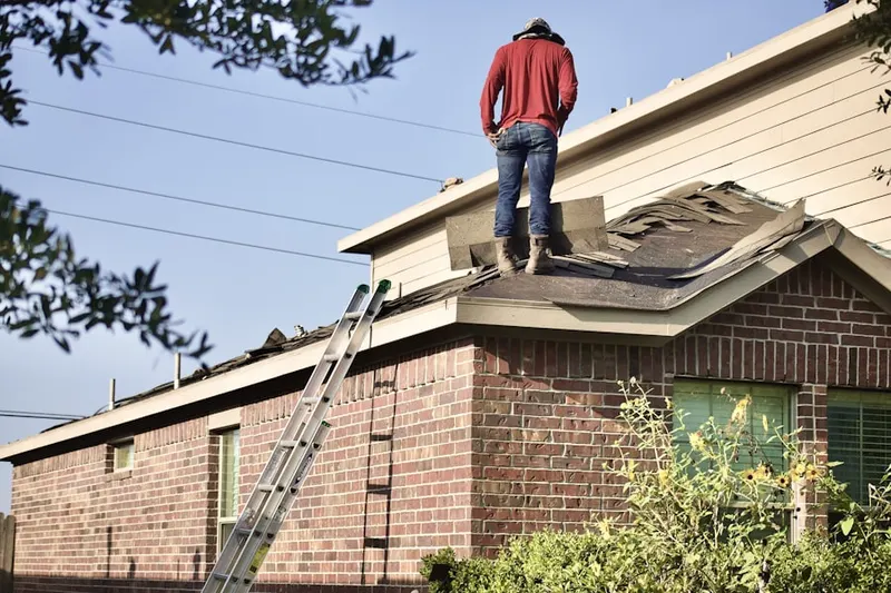 Professional roofer working on a residential roof in West Sayville